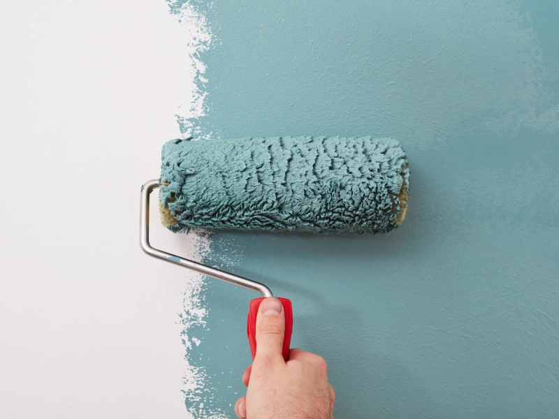 Fotografía de un rodillo de pintura sobre una pared